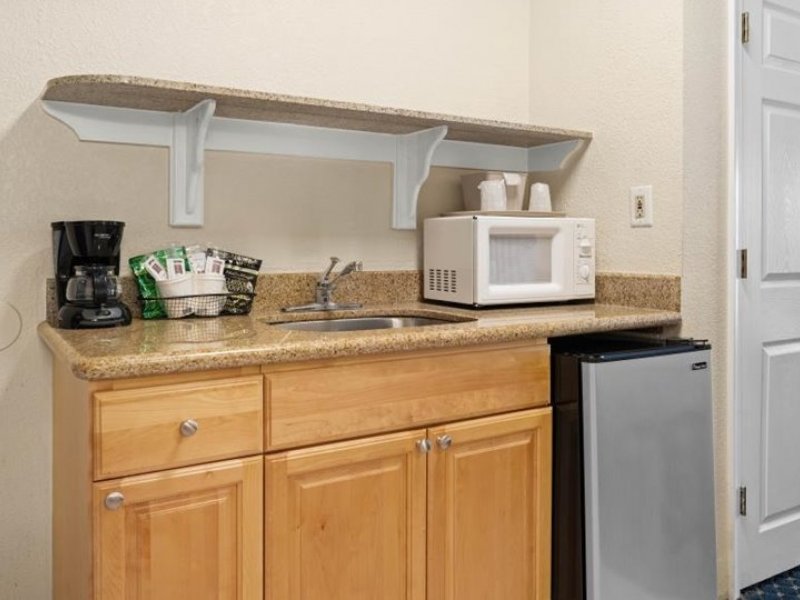 a kitchen with a refrigerator, microwave and coffee maker