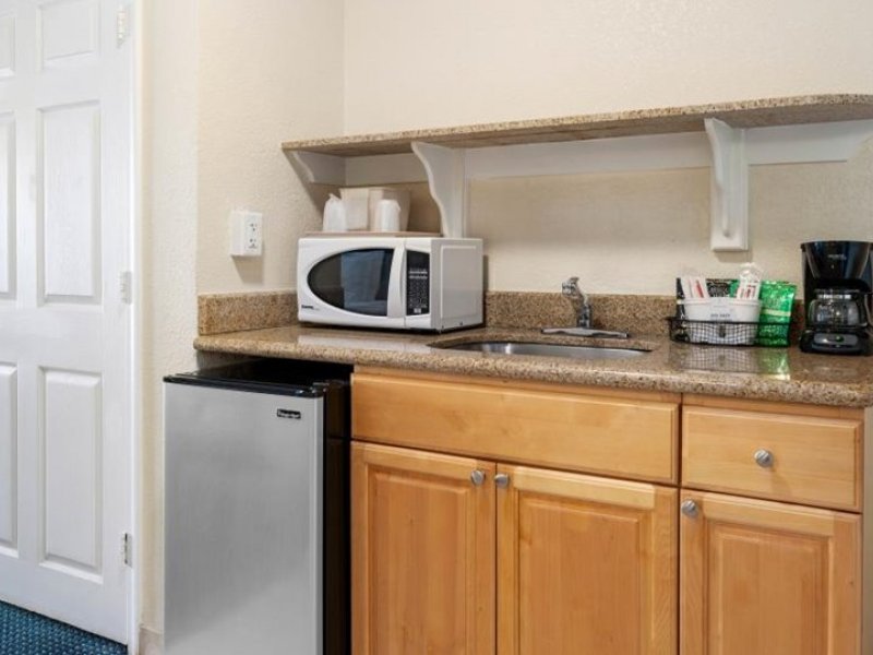 a kitchen with a refrigerator, microwave and sink