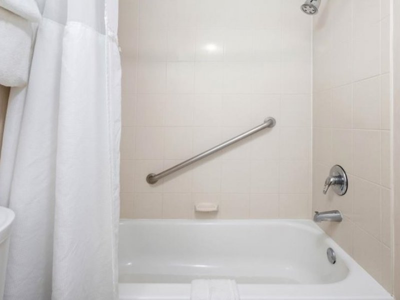 a white bathroom with a shower and bathtub