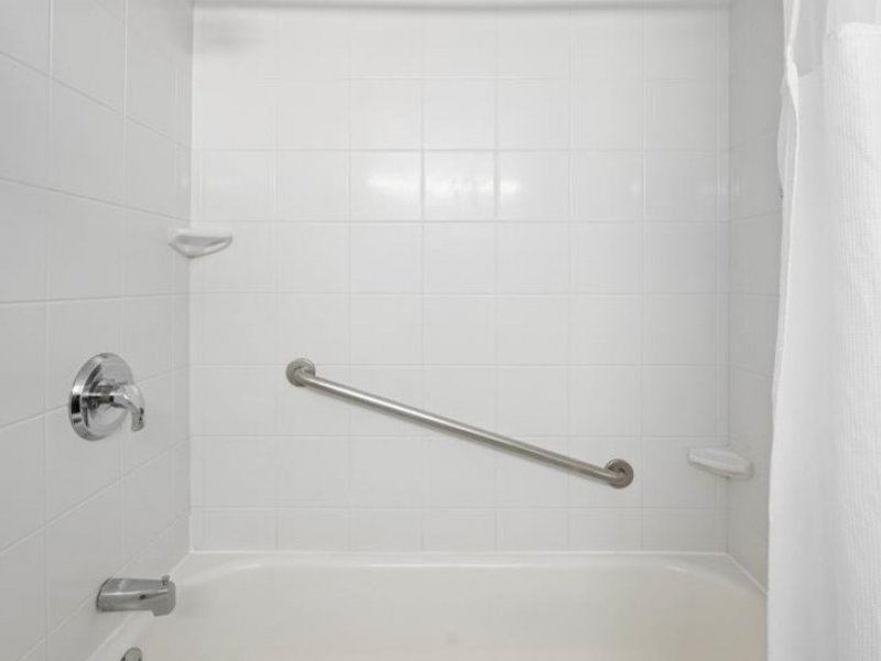 a bathroom with a white shower curtain next to a bath tub