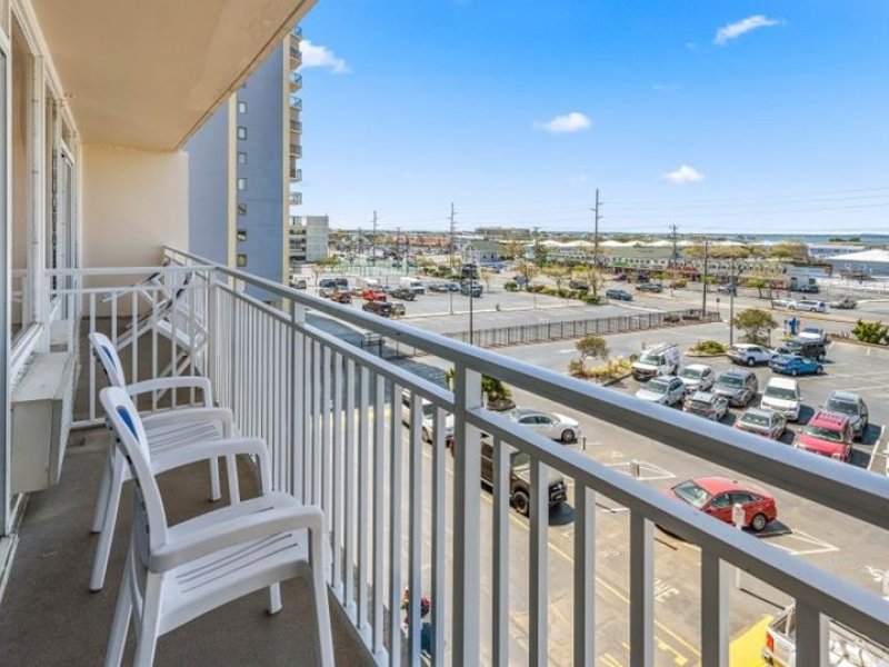 a balcony with chairs and a view of the parking lot