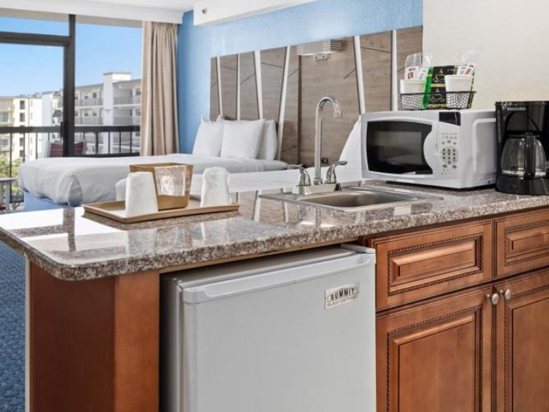 a hotel room with a kitchenette, sink and refrigerator