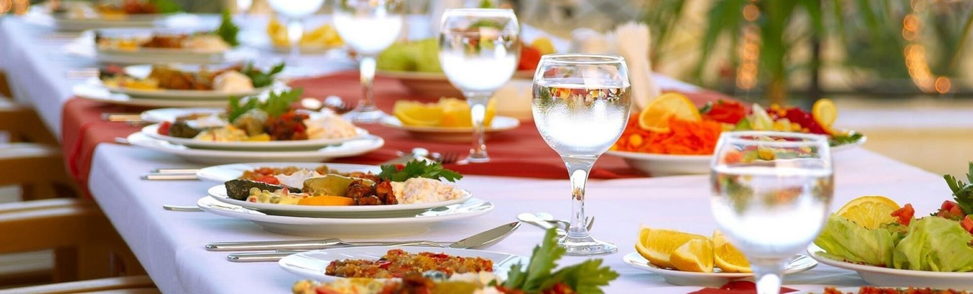 a long table is set with plates and glasses