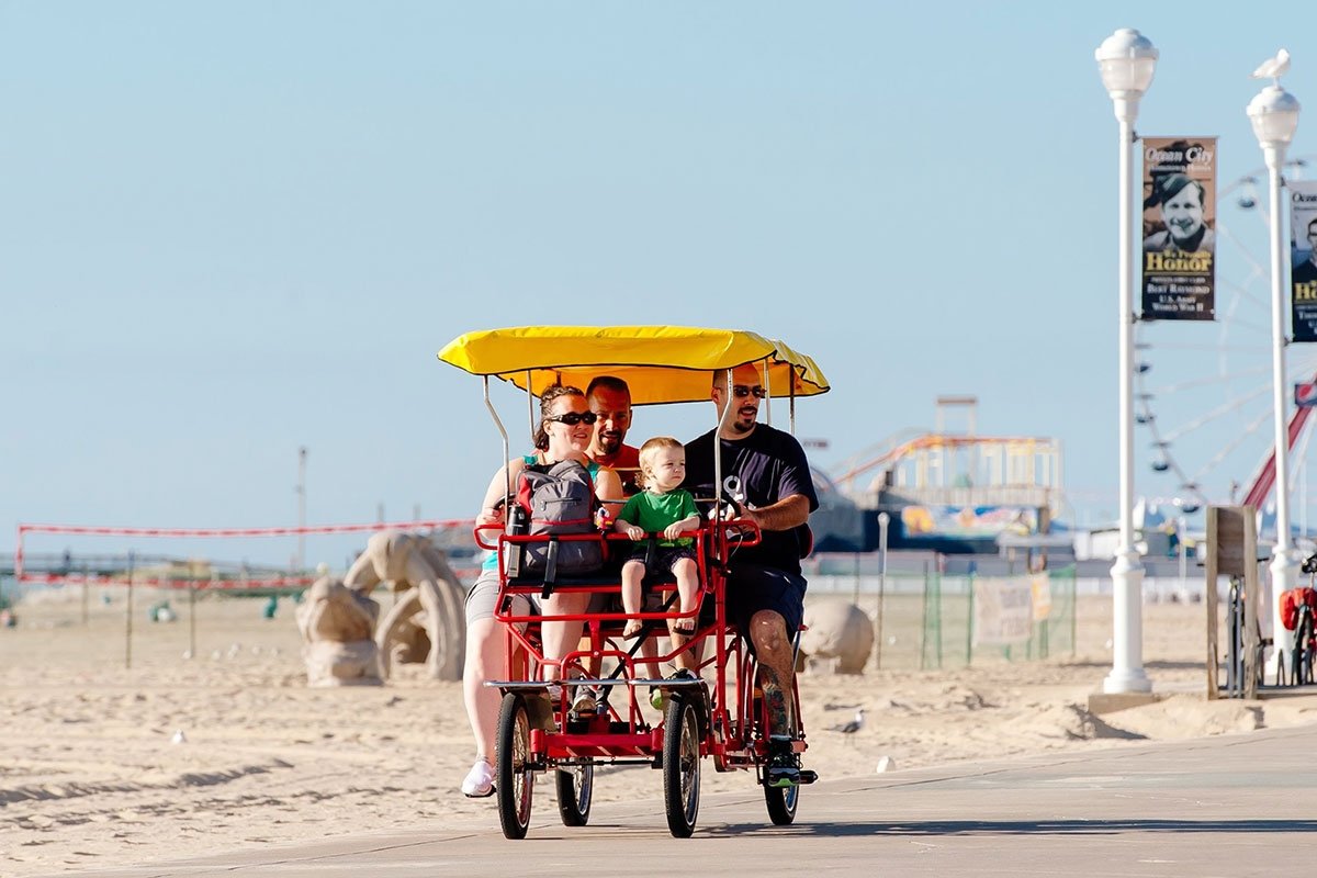 a man and woman riding on a red bike with a child in the back