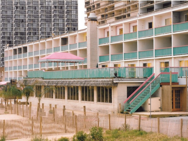 an old building with balconies and a pink umbrella