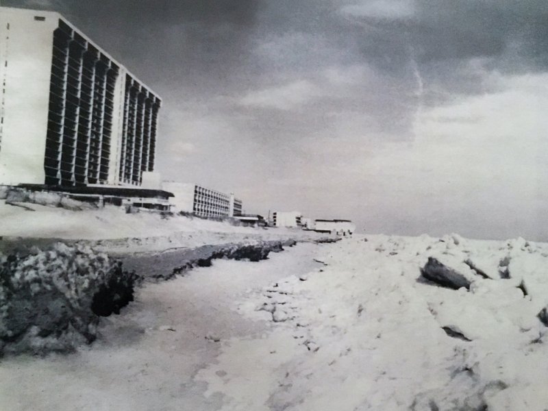 a black and white photo of a beach covered in snow