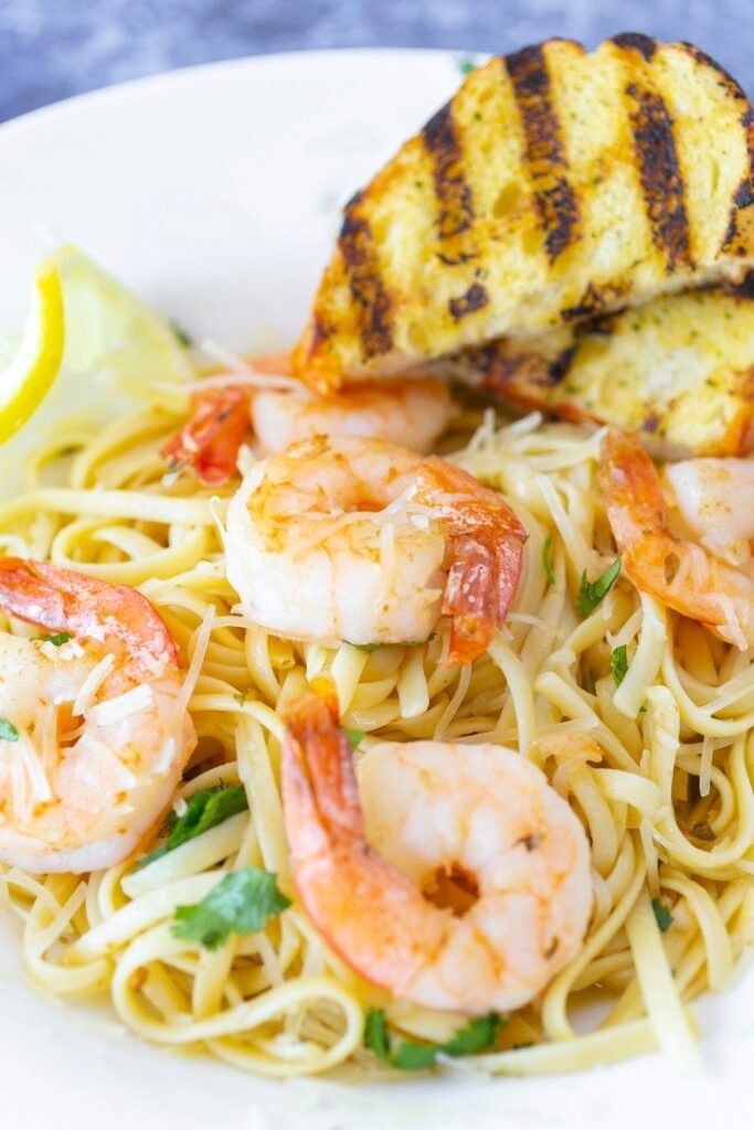 a white plate topped with pasta and shrimp