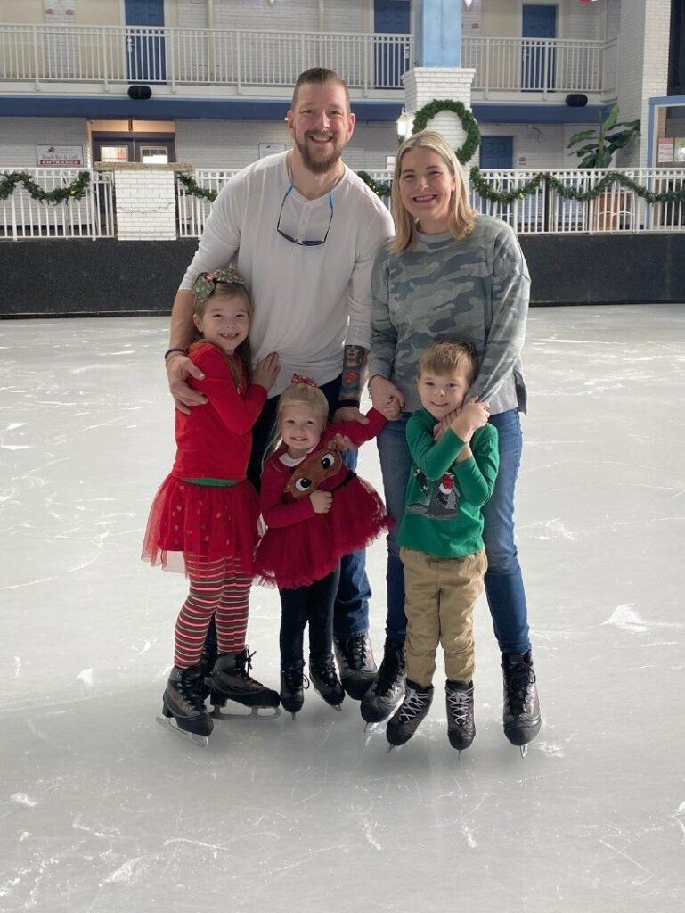a family poses for a photo on an ice rink