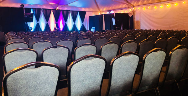 rows of chairs in front of a stage with lights