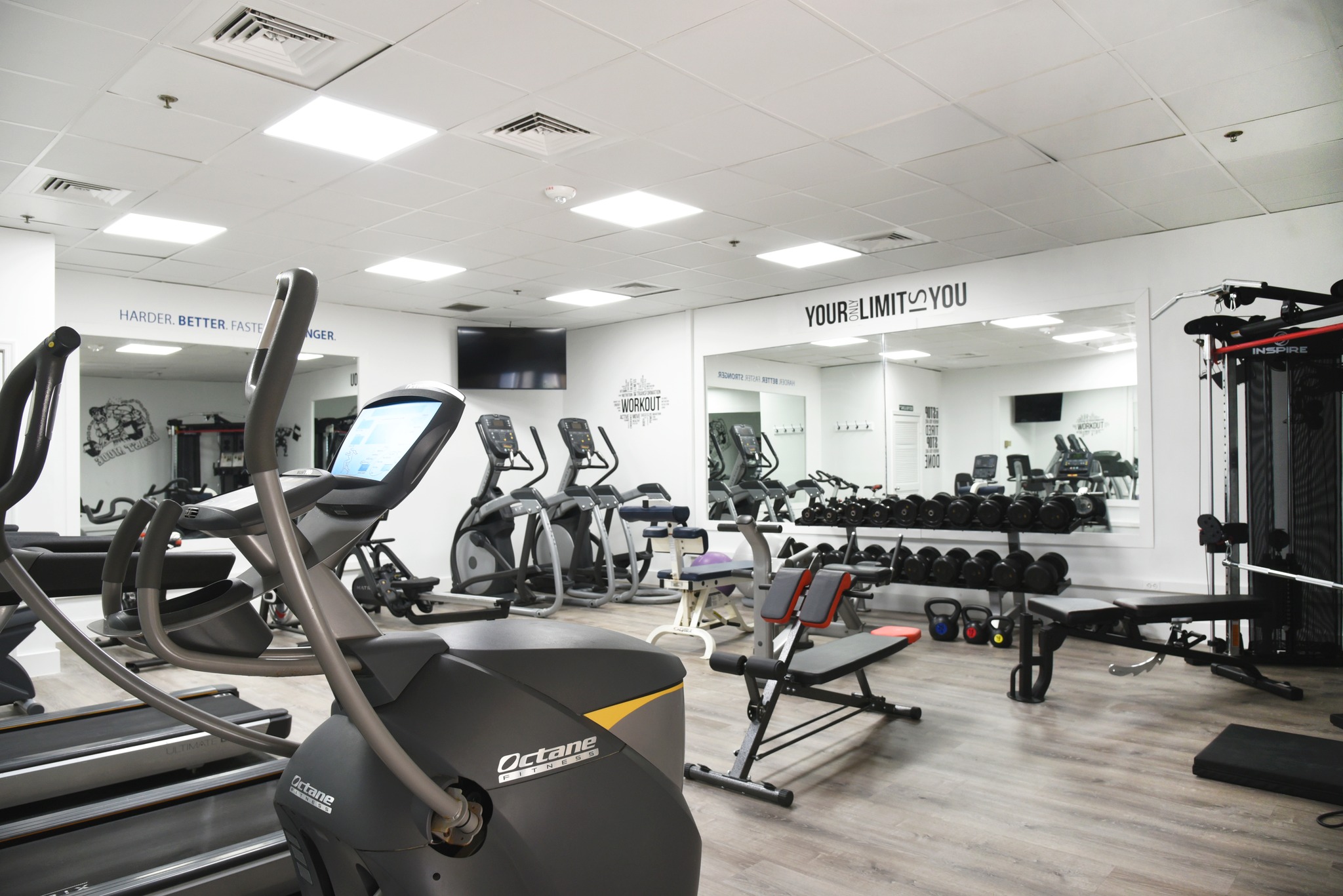 a gym with treadmills, exercise bikes and mirrors