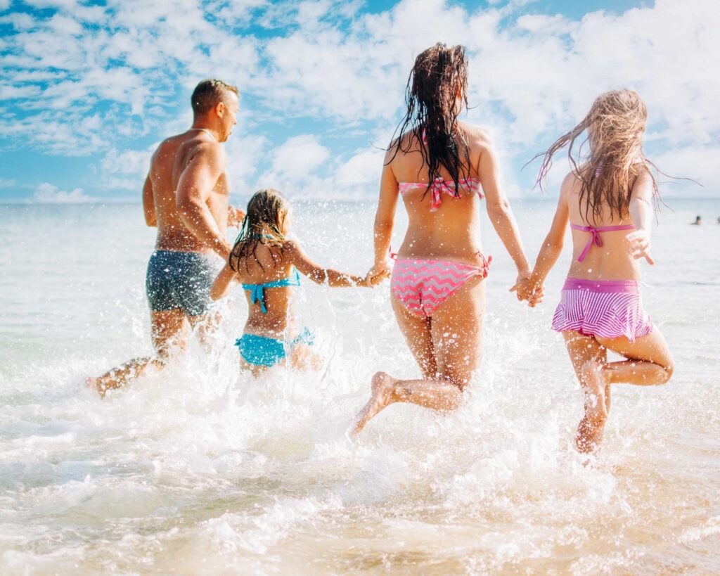a group of people running into the ocean