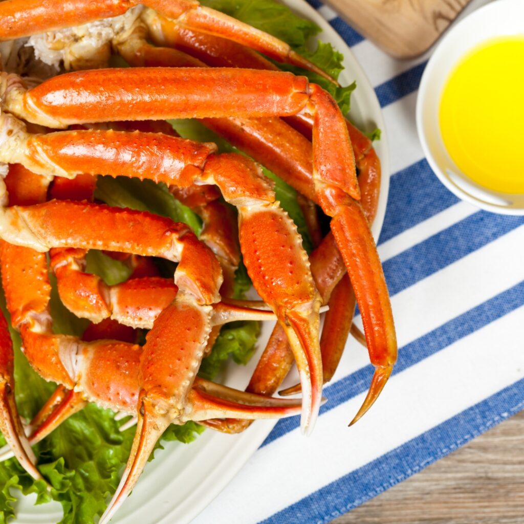 a plate of cooked lobsters with lettuce and sauce